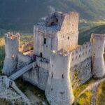 Veduta aerea della meravigliosa Rocca di Calascio il cui fascino è stato fonte d'ispirazione per registi del calibro di Anton Corbijn, in The American con George Cloney, e Richard Donner che l' ha fortemente voluta per le riprese di Ladyhawke. Memorabile la scena in cui Michelle Pfeiffer, nel ruolo di Isabeau D'Anjou, precipita nel vuoto per poi trasformarsi in falco con le prime luci dell'alba. In molti ci identificano il borgo de Il nome della rosa anche se Umberto Eco ha dichiarato che la location delle riprese fu costruita per l'occasione con tecnologie tipiche degli studios cinematografici.